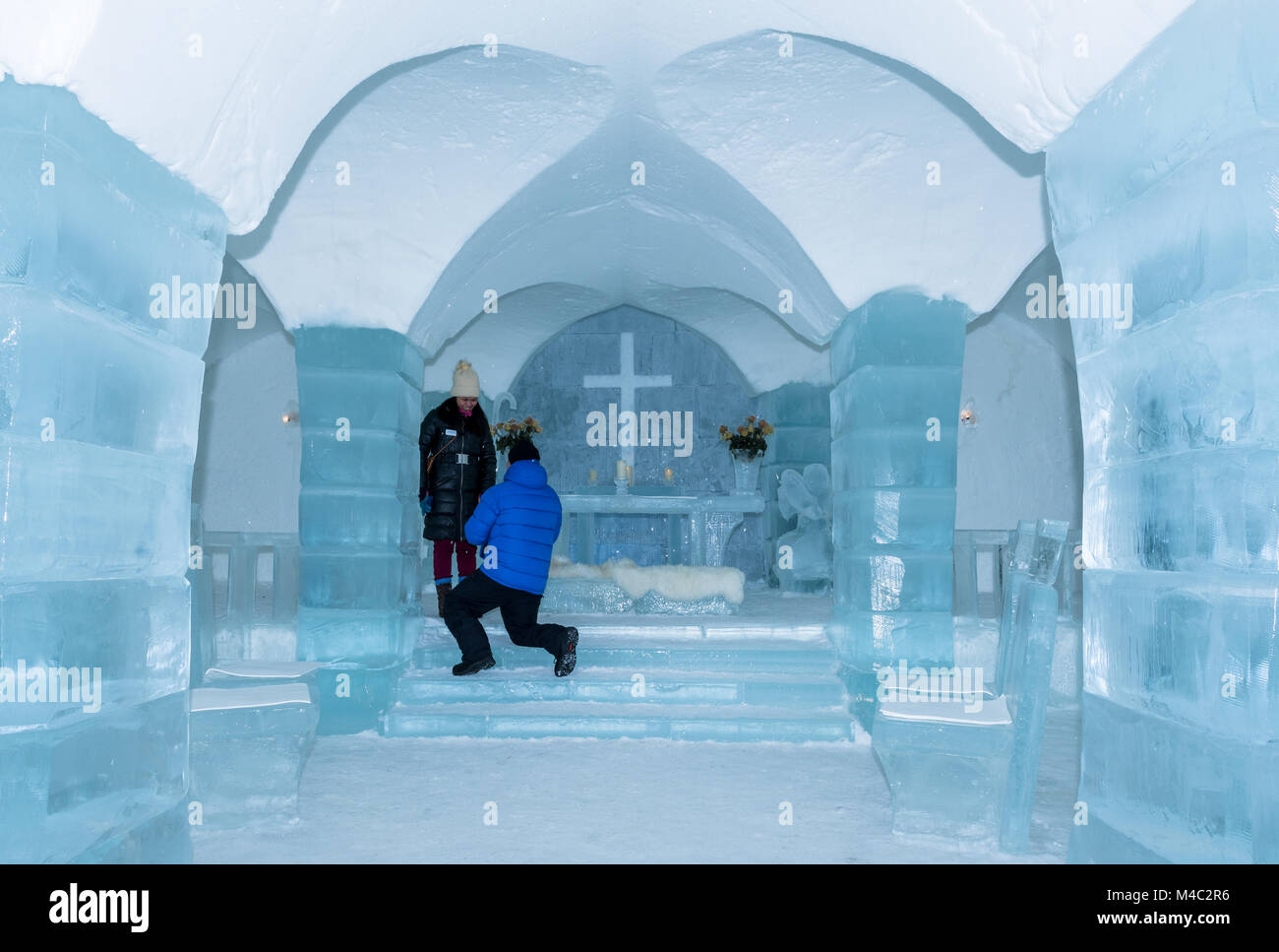 Two people in ice hotel church, guy propose to his girlfriend Stock Photo