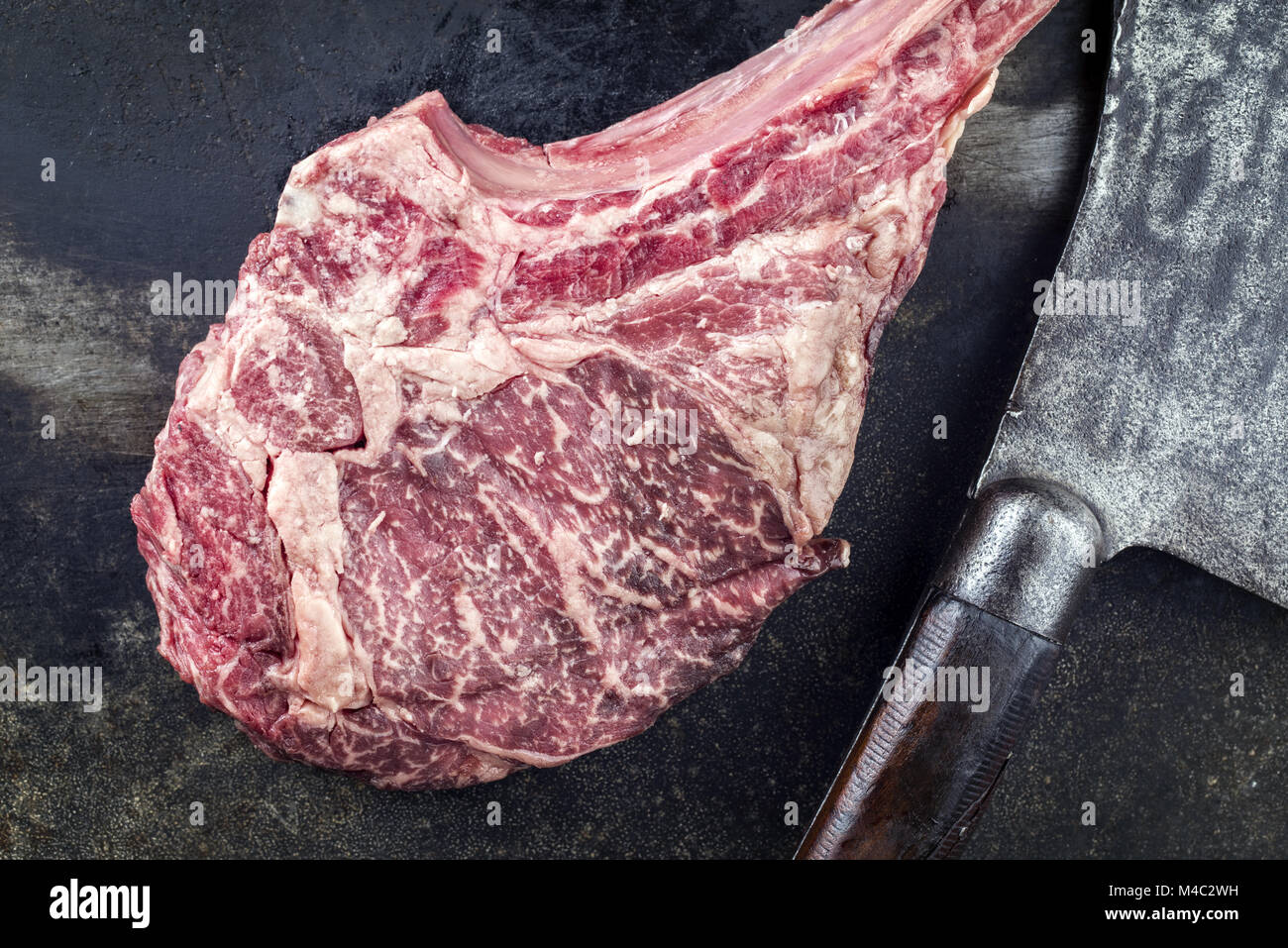 https://c8.alamy.com/comp/M4C2WH/wagyu-tomahawk-steak-with-old-chopper-on-metall-sheet-M4C2WH.jpg