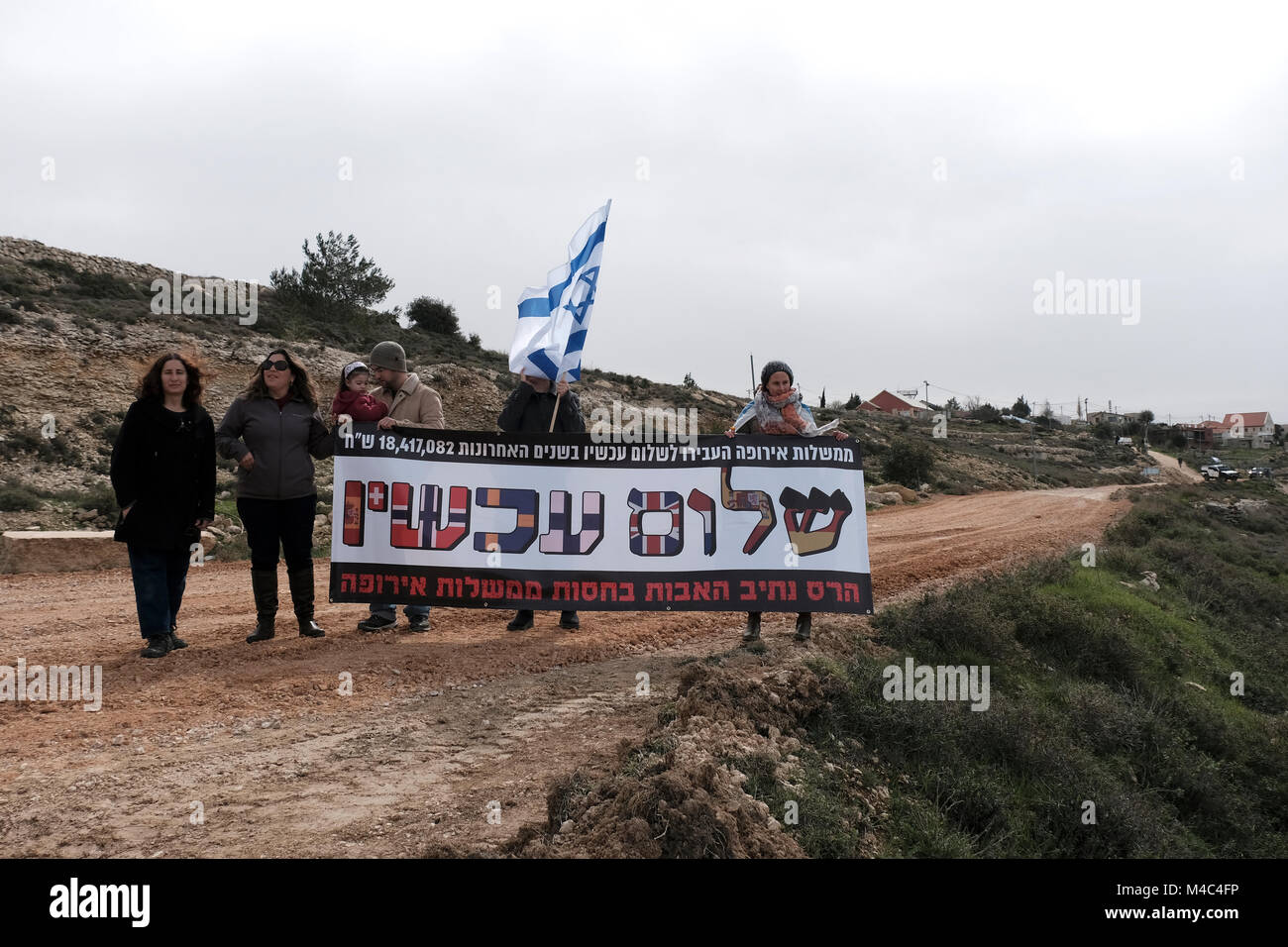 Nativ Ha'avot, Israel. 15th Feb, 2018. Activists from the right wing Zionist organization Im Tirtzu holds a sign reading “Peace Now, Destruction of Netiv Ha’avot, with support of European governments” n a counter protest to leftists from Peace Now movement who arrived to Nativ Ha'avot following Israeli government attempts to postpone the removal of some of the houses in the Jewish outpost despite the Supreme Court ruling. Credit: Eddie Gerald/Alamy Live News Stock Photo