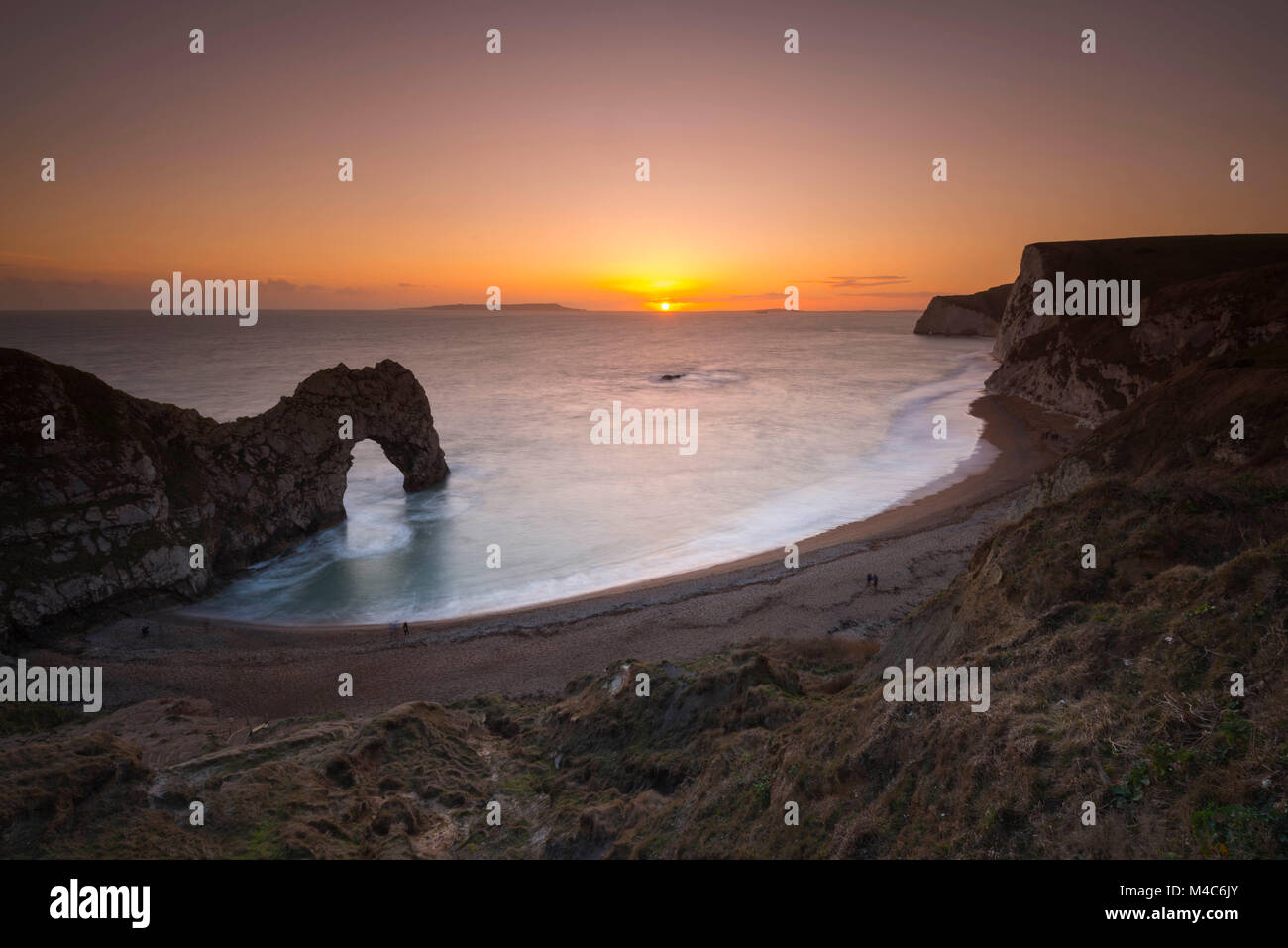 Lulworth, Dorset, UK.  15th February 2018.  UK Weather.  Sunset at the limestone sea arch of Durdle Door near Lulworth on the Jurassic Coast of Dorset on a cold sunny day with the cliffs of Swyre Head on the right.  Picture Credit: Graham Hunt/Alamy Live News. Stock Photo
