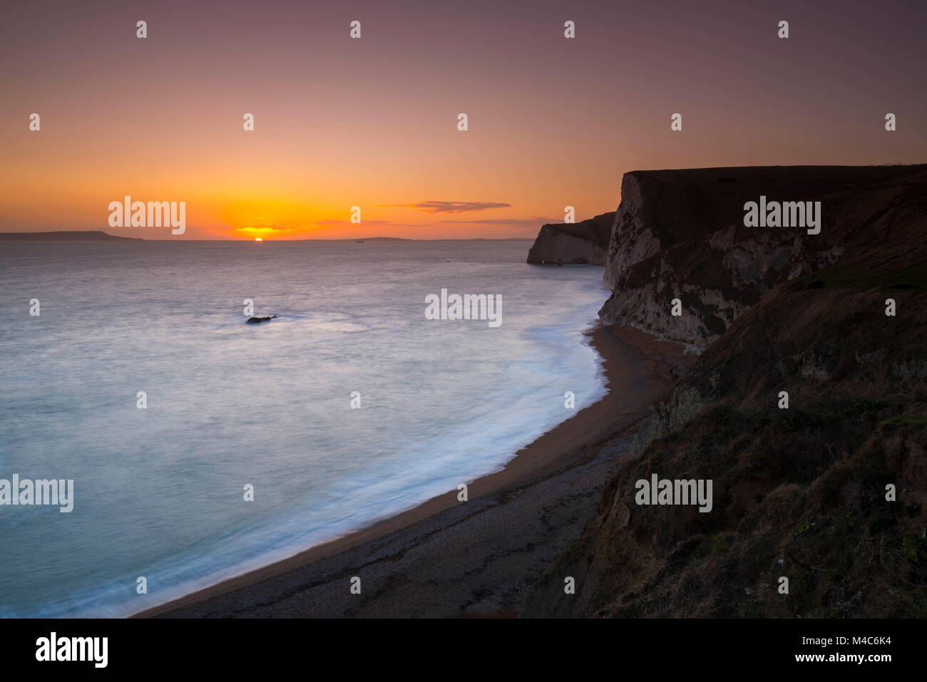 Lulworth, Dorset, UK.  15th February 2018.  UK Weather.  View of the sunset with the cliffs of Swyre head on the right near Lulworth on the Jurassic Coast of Dorset on a cold sunny day.  Picture Credit: Graham Hunt/Alamy Live News. Stock Photo