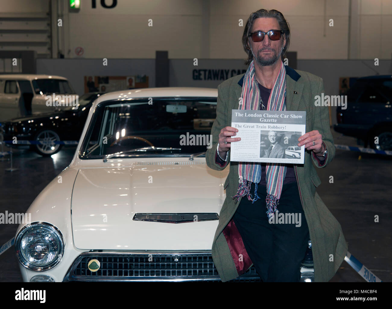 Nick Reynolds poses with his father's Lotus Cortina from the Great Train Robery, on the Getaway Cars Display, during the 2018 London Classic Car Show Stock Photo
