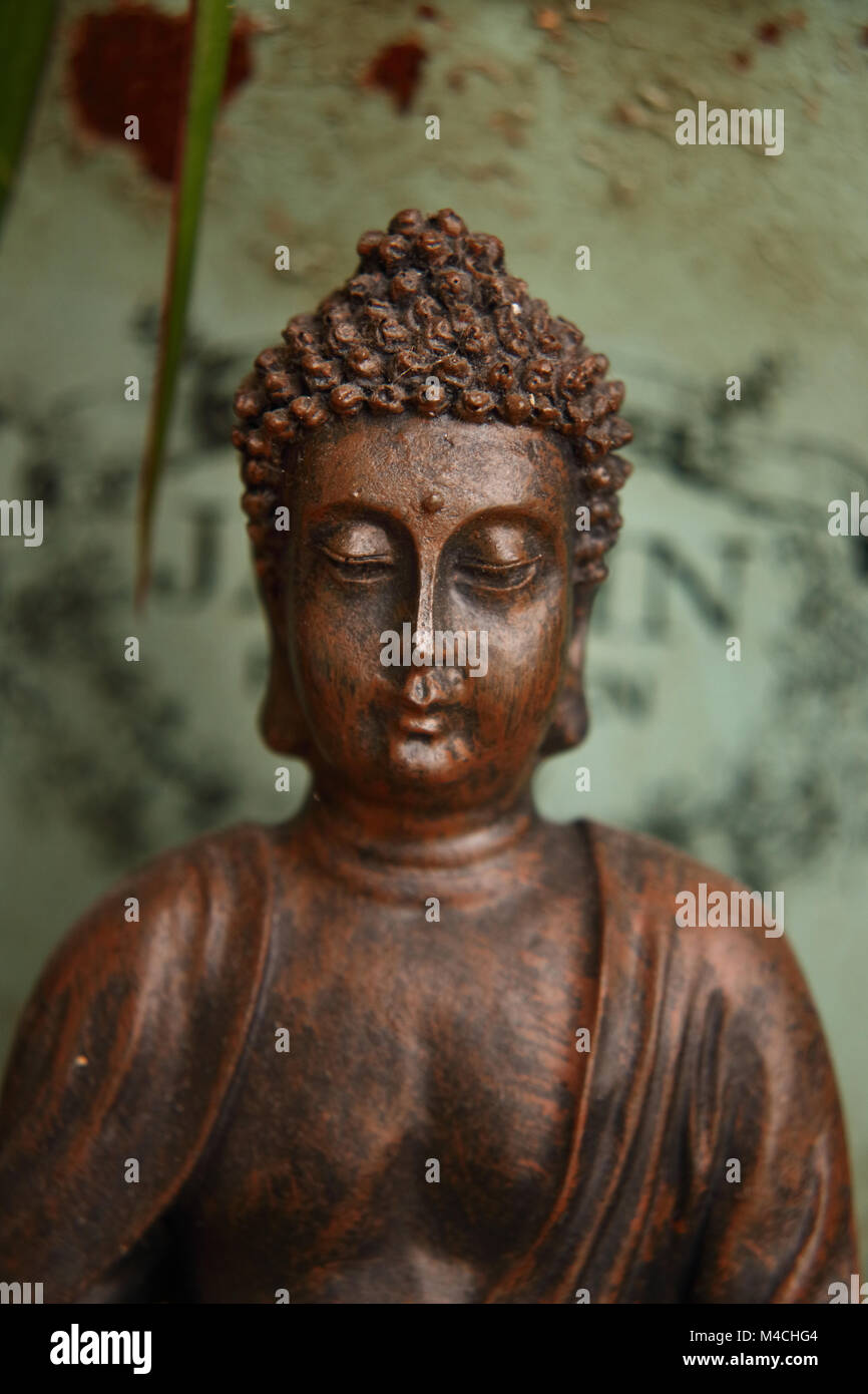buddha against a green metal background Stock Photo