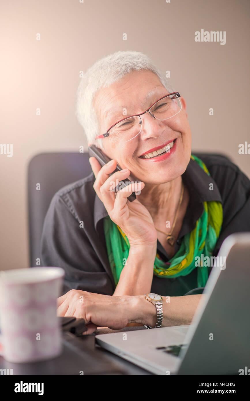 Cheerful business talk, senior lady Stock Photo