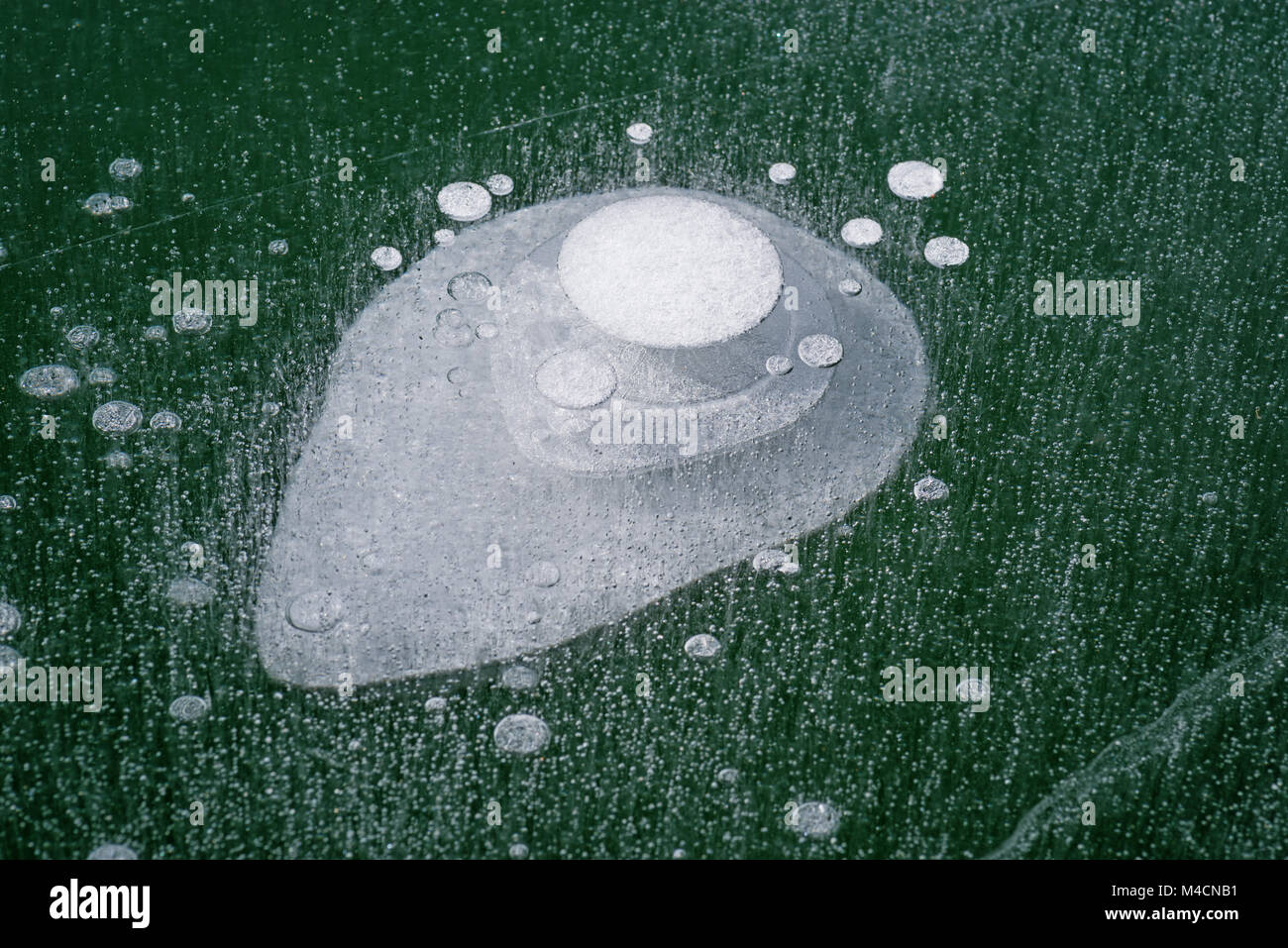 layers of air bubbles frozen in clear lake ice Stock Photo