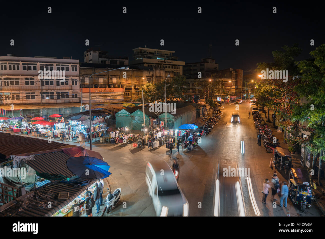 CHIANG MAI,  THAILAND - JANUARY 29 2018; high point of view onto city street night markets with people and vehicles blurred in motion Stock Photo