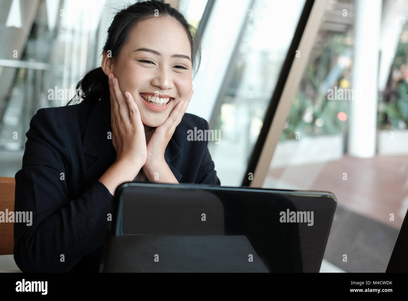 businesswoman put hand on face with happiness for successful project. cheerful woman showing gladness for achievement Stock Photo