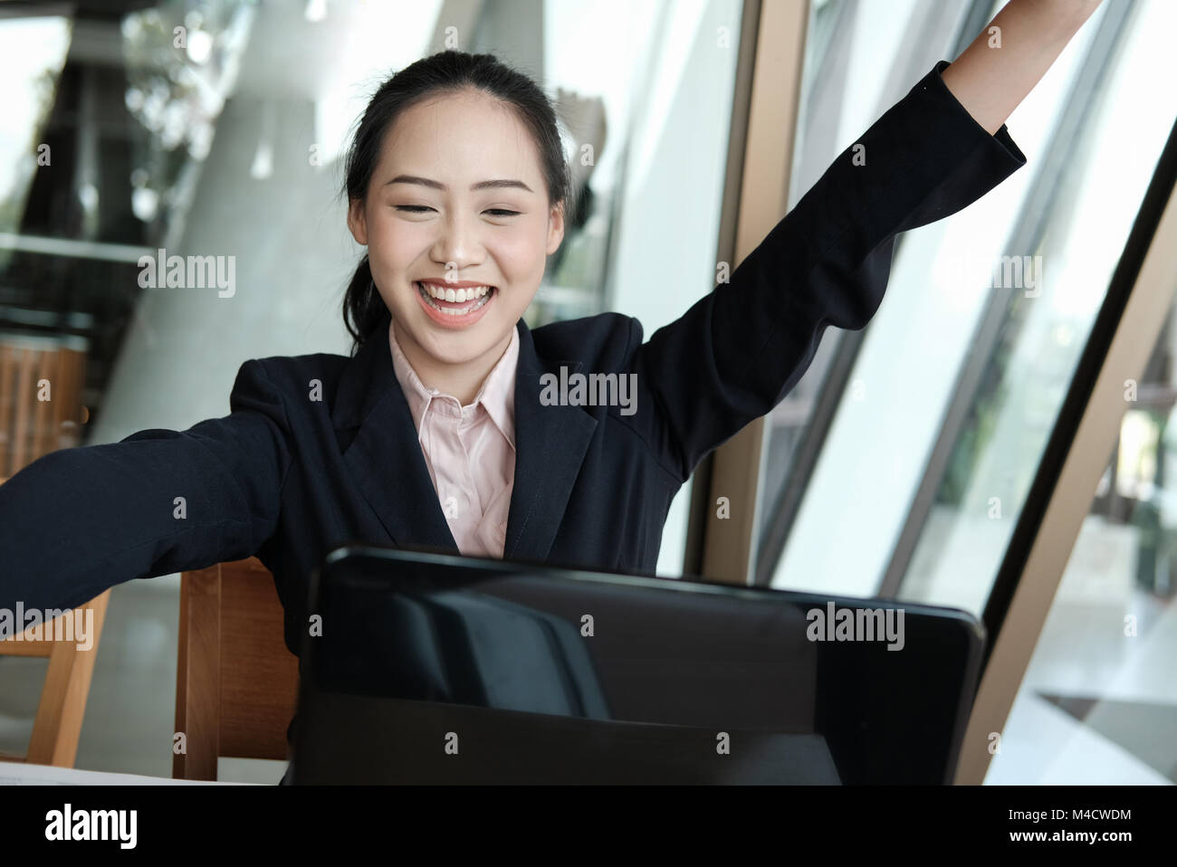 businesswoman raise hands with happiness for successful project. cheerful woman showing gladness for achievement Stock Photo