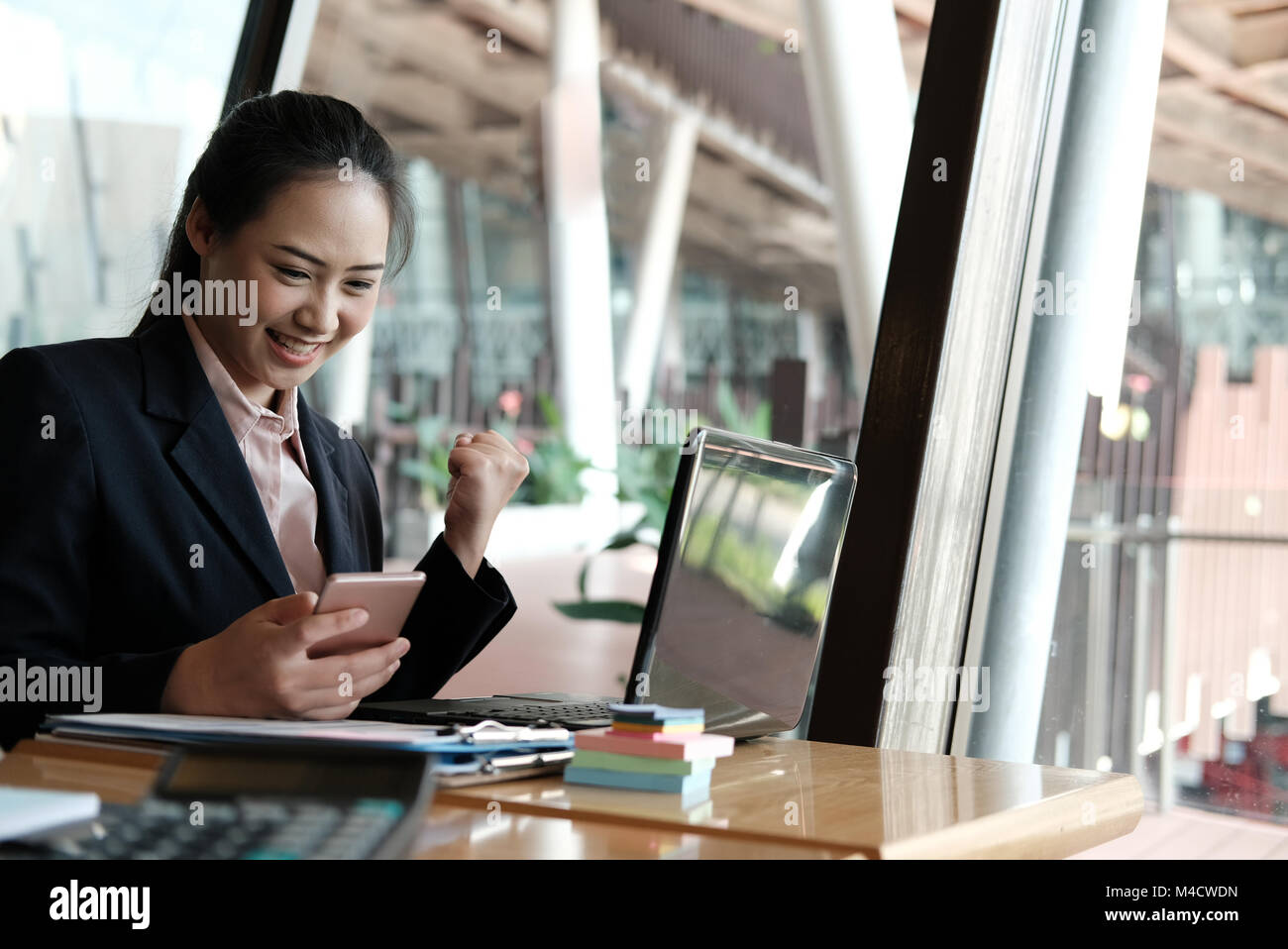 young startup woman raise fist with yes gesture at office. freelance female entrepreneur glad with successful project. businesswoman working at workpl Stock Photo