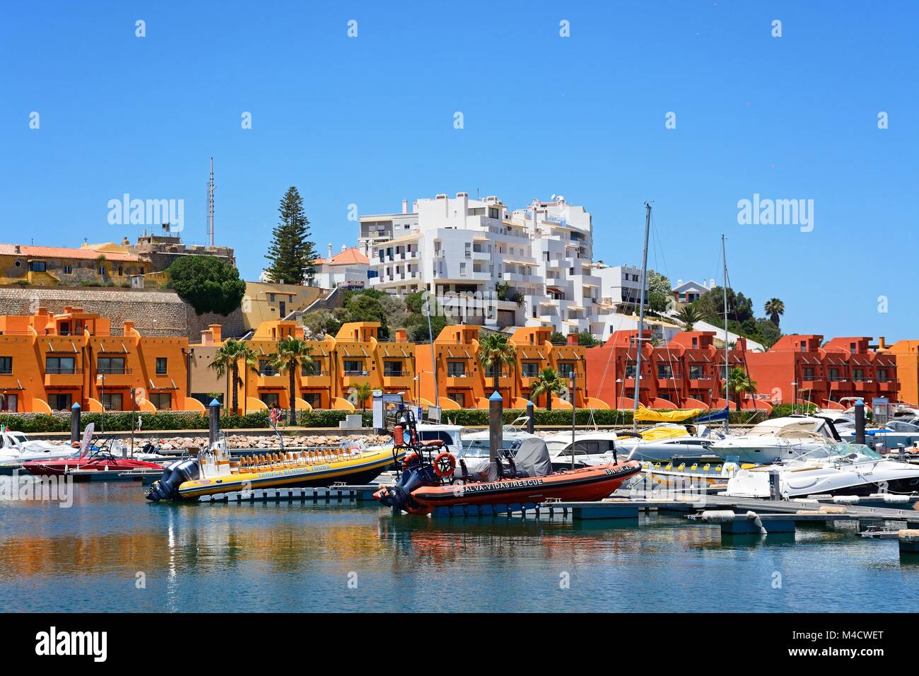 Yachts and motorboats moored in the marina with apartments to the rear, Portimao, Algarve, Portugal, Europe. Stock Photo