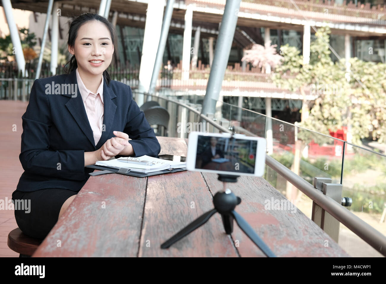 asian businesswoman use smartphone for online live streaming. woman recording video blog. vlogger presenting business vlog. Stock Photo