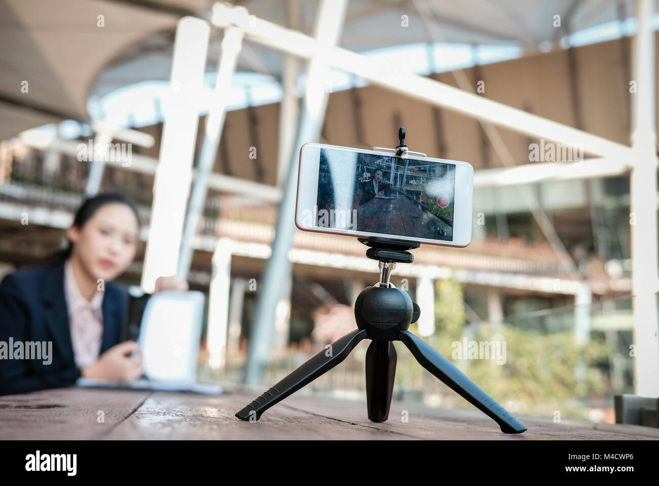 asian businesswoman use smartphone for online live streaming. woman recording video blog. vlogger presenting business vlog. Stock Photo