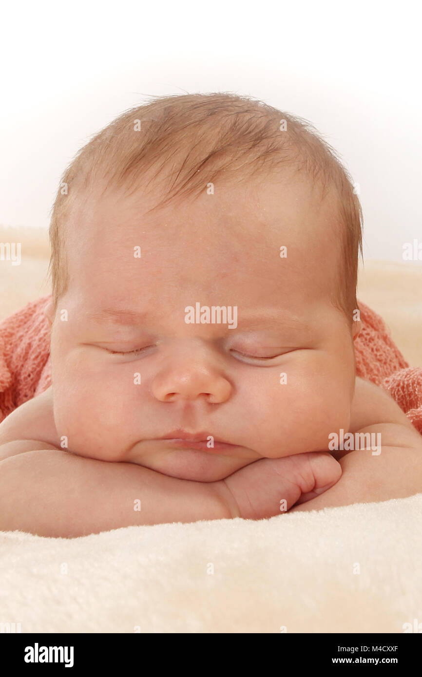 Newborn baby girl sleeping in nursery, beautiful new baby relaxed and