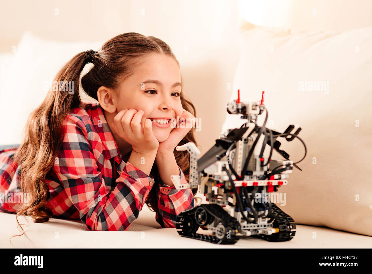 Extremely happy young lady examining robotic machine Stock Photo