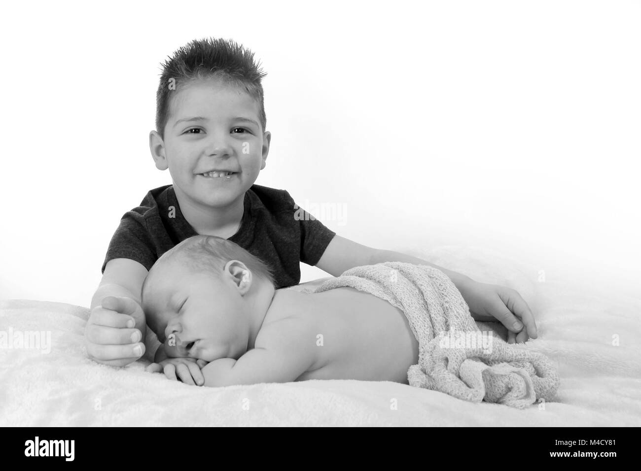 big brother and baby sister together happy and having fun in the nursery Stock Photo