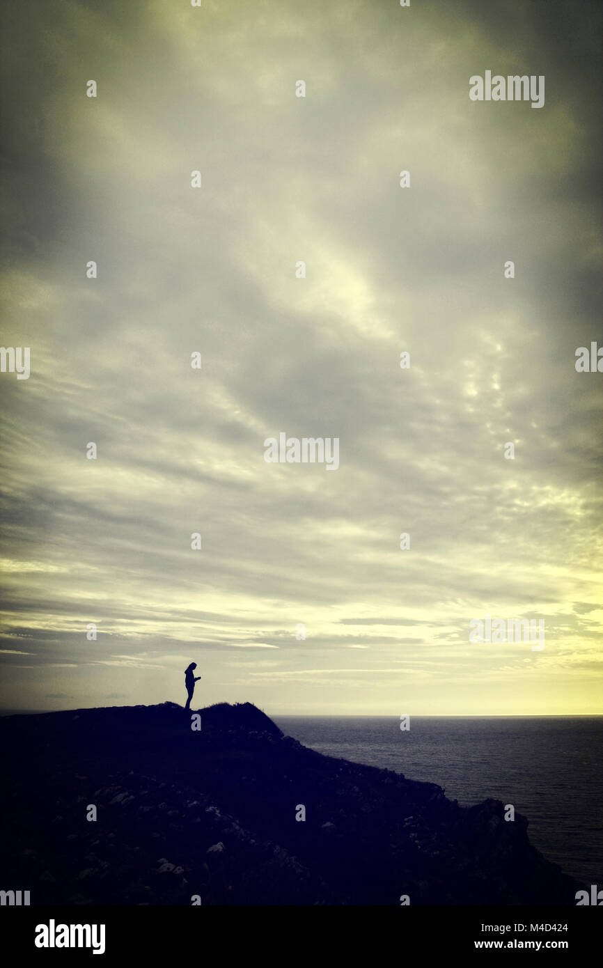 Woman standing on cliff retro hi-res stock photography and images - Alamy