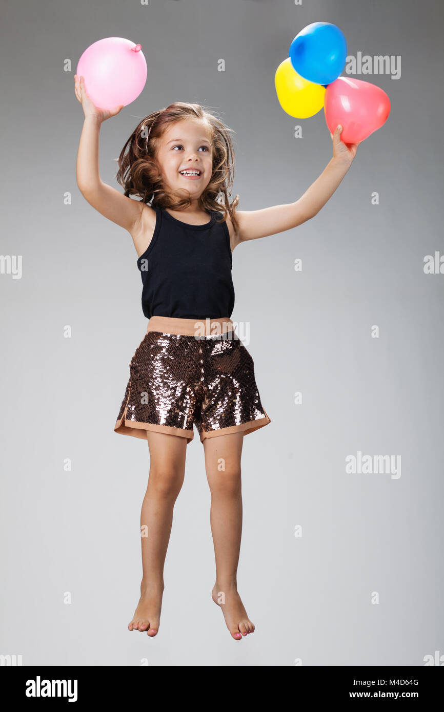 little girl jumping in the air with balloons Stock Photo - Alamy
