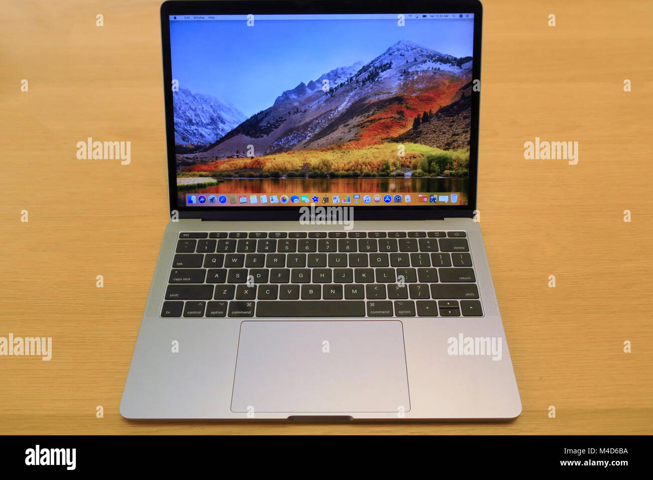 An apple mac book pro sitting on an oak table. Stock Photo