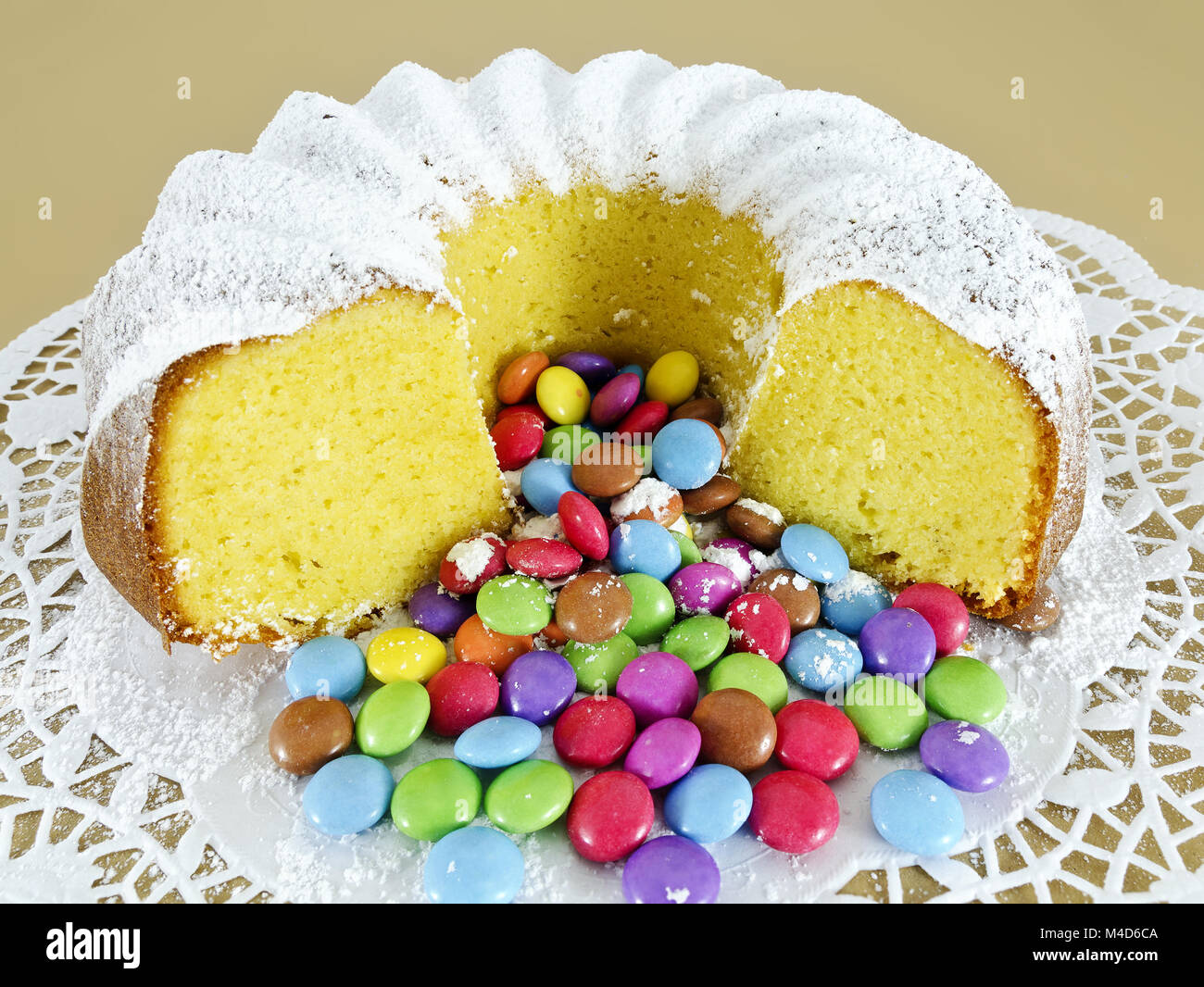 ring-shaped sponge cake and colour-varied sugar-coated chocolate confectionery Stock Photo