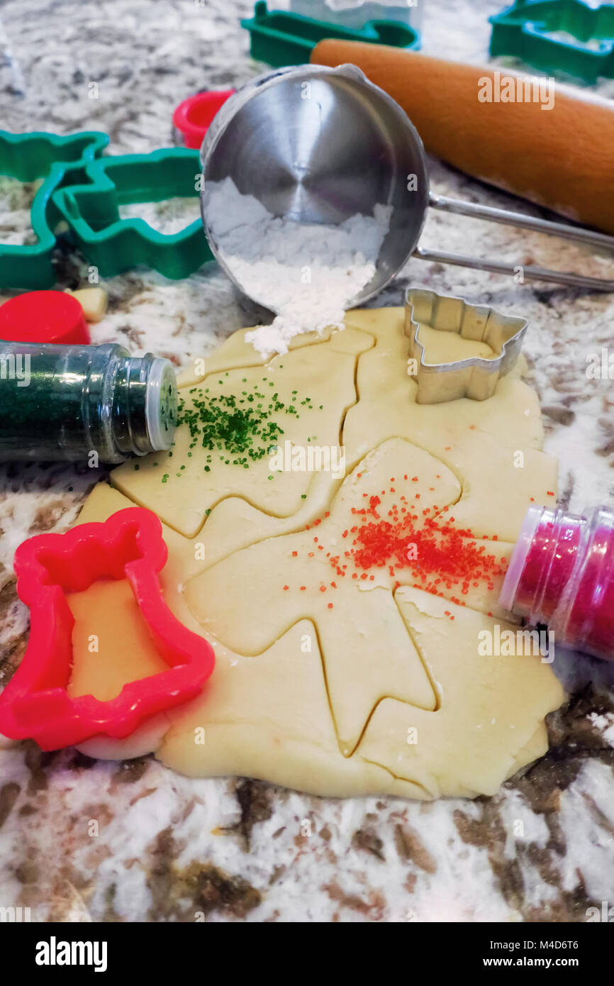 Red and green Sprinkles spilling out onto sugar cookie dough Stock