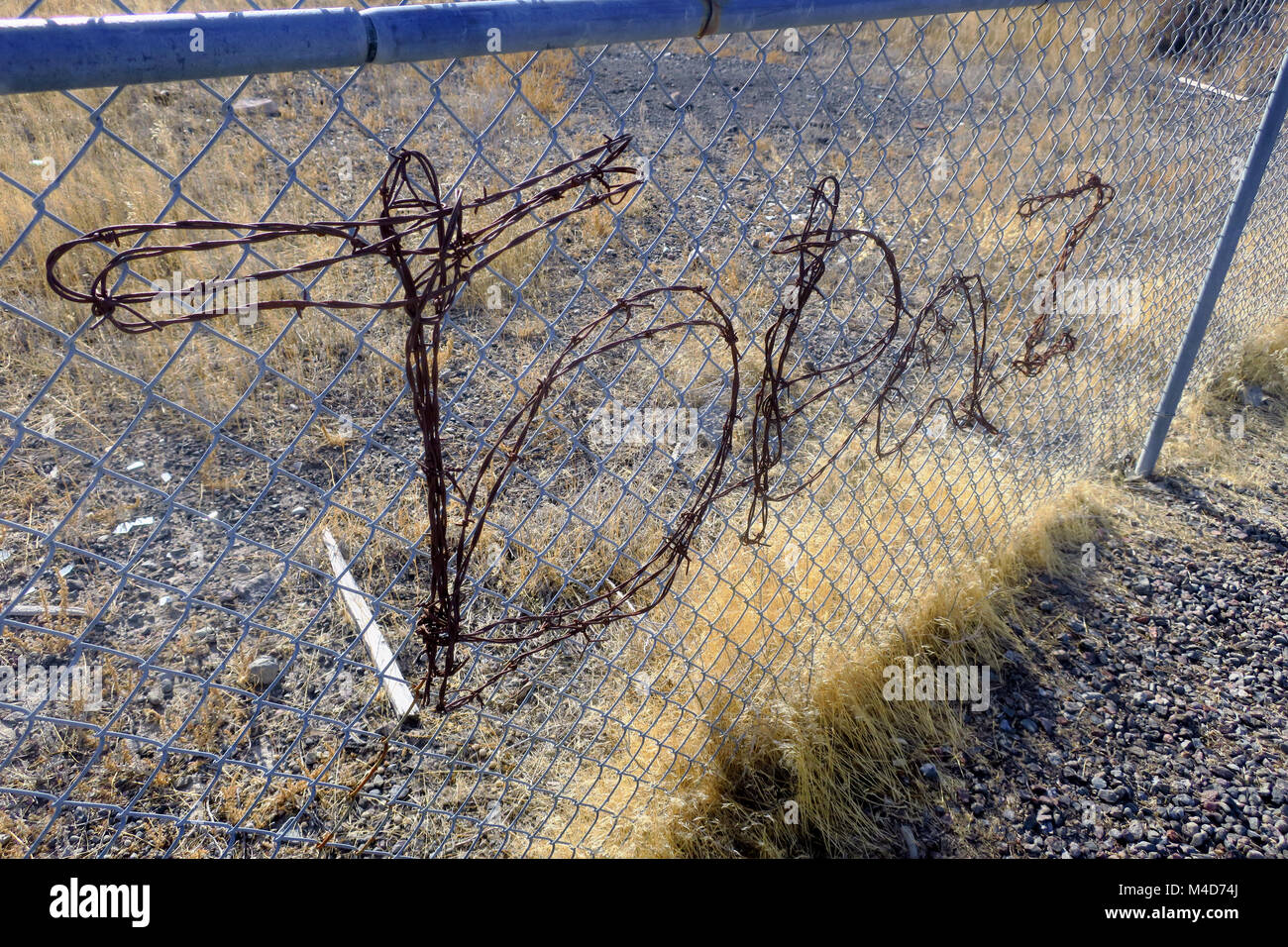 Topaz interment camp illustrated by wire on a fence near a monument in Central Utah. Stock Photo