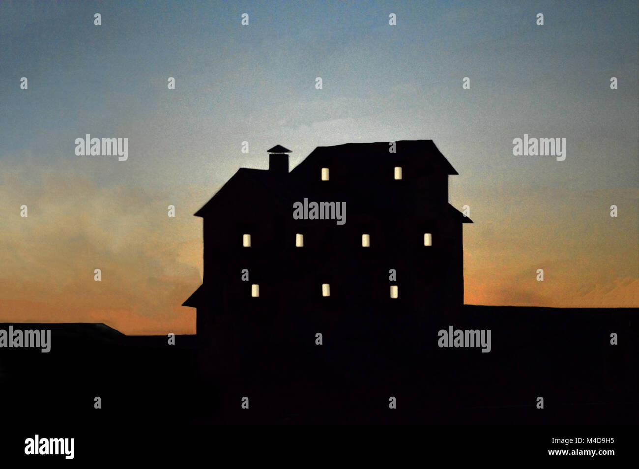 A large, spooky and mishapen building  silhouetted house aginast a darkening sky at dusk. Stock Photo
