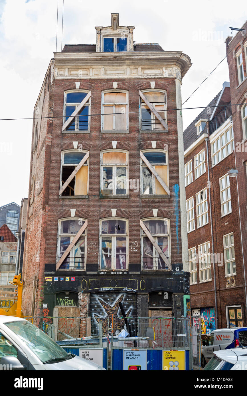 Multi unit building,in Amsterdam, undergoing renovation. Graffiti on street level. Apartment construction site in the city. Stock Photo