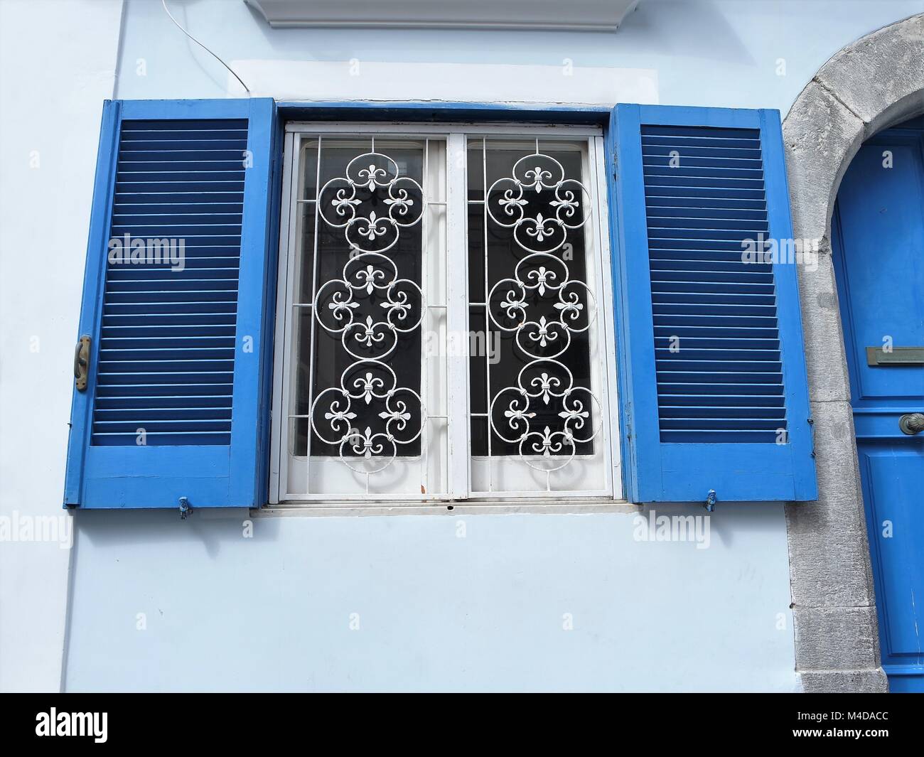 Windows with grilles and window shutters Stock Photo