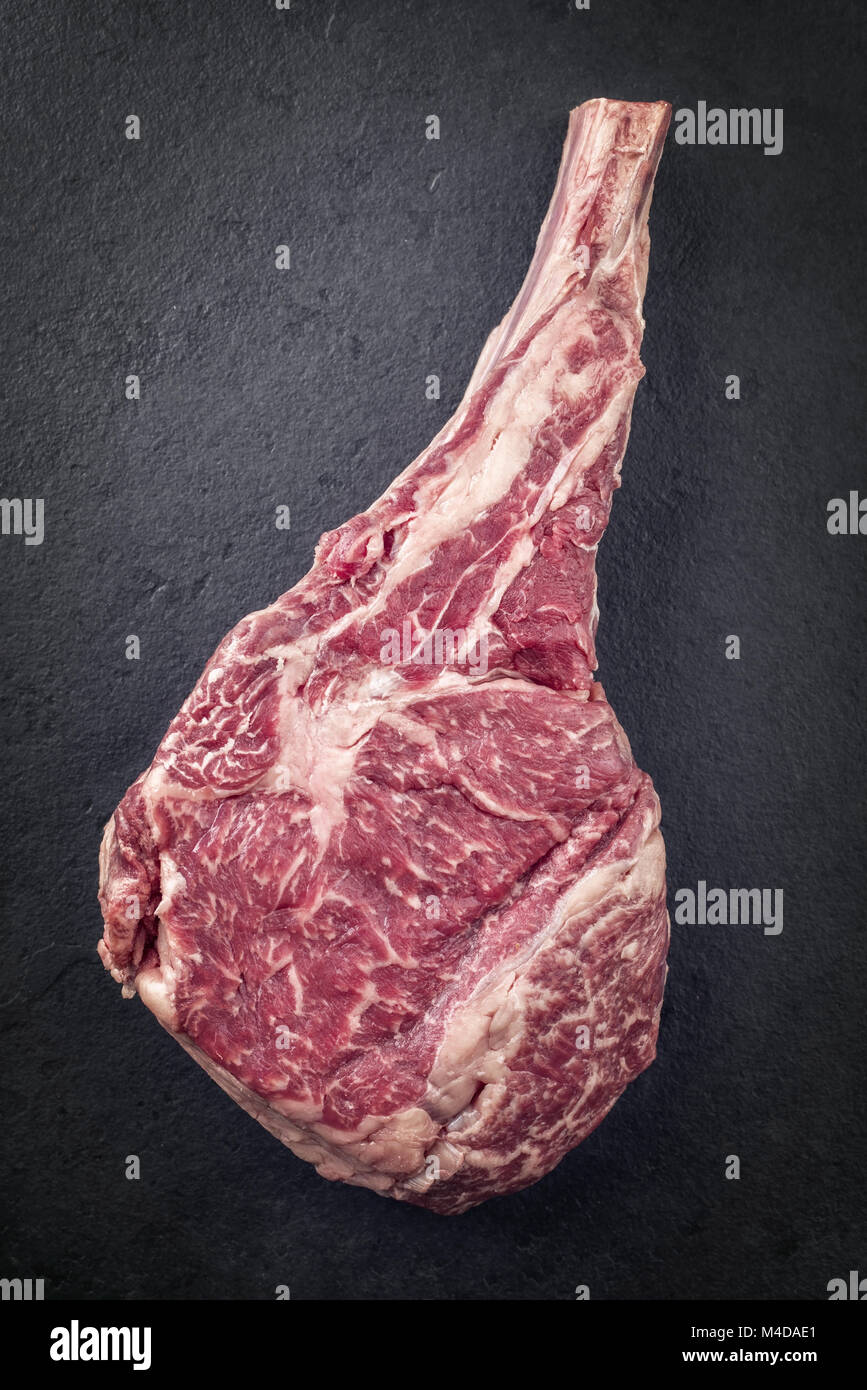 Raw dry Aged Wagyu Tomahawk Steak on a Slate Stock Photo