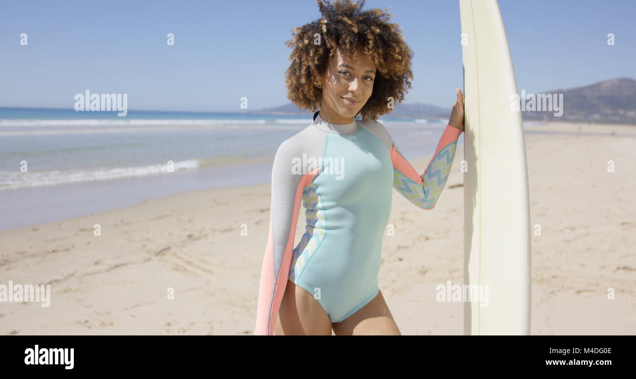 Female with surfboard posing on Tarifa beach Stock Photo