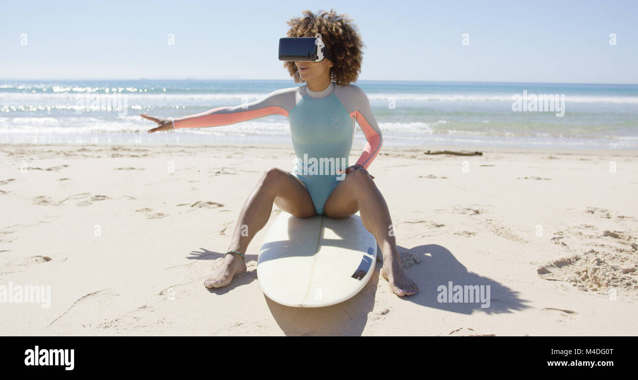 Female wearing virtual reality glasses on beach Stock Photo