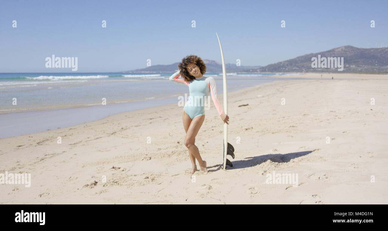 Female posing on beach with surfboard Stock Photo