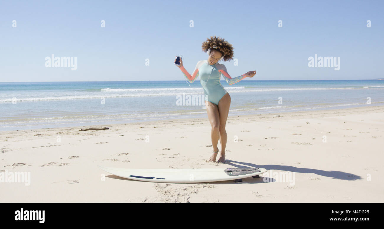 Female listening music and dancing on beach Stock Photo