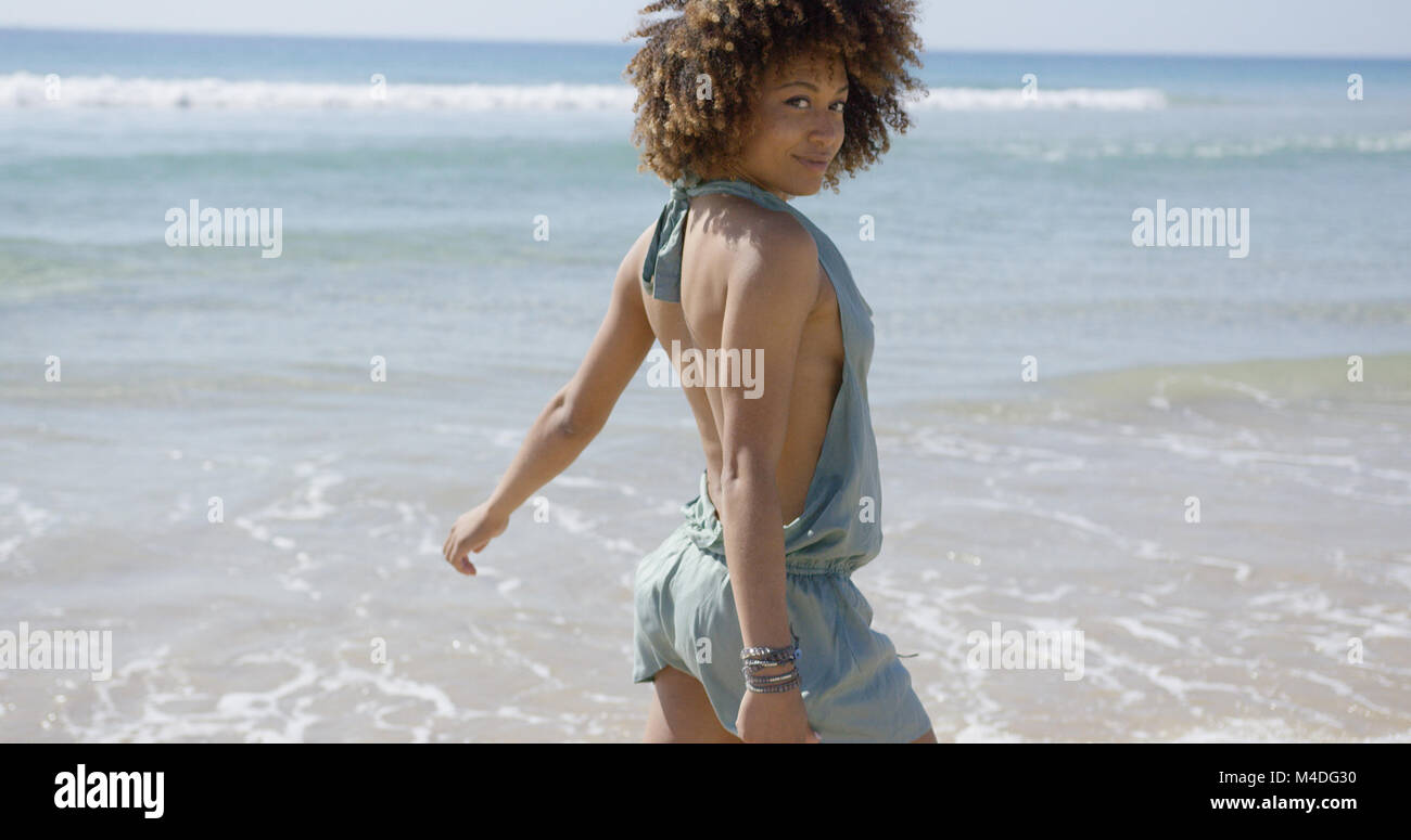Female wearing summer jumpsuit posing on beach Stock Photo