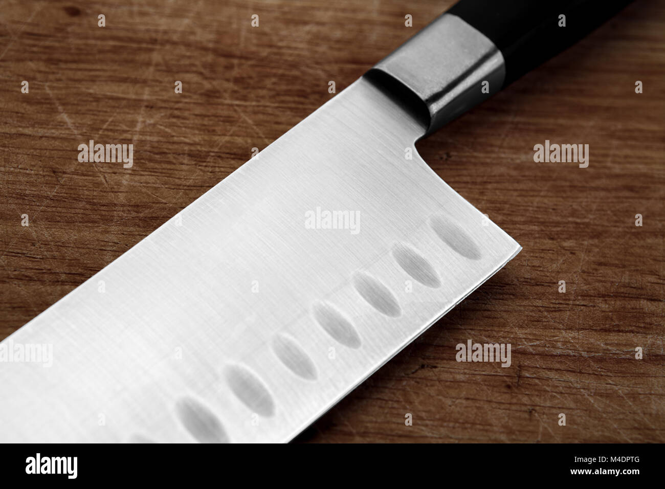 part of the kitchen knife on an old cutting board Stock Photo