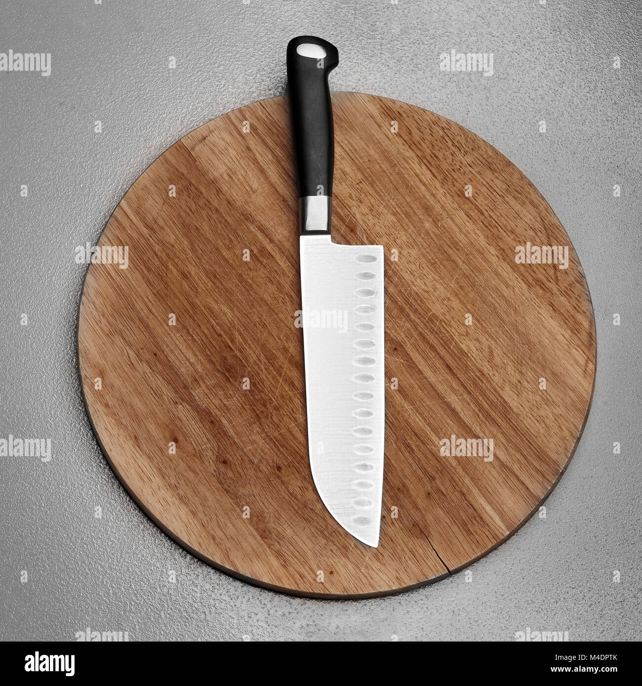 kitchen knife lying on an old cutting board Stock Photo