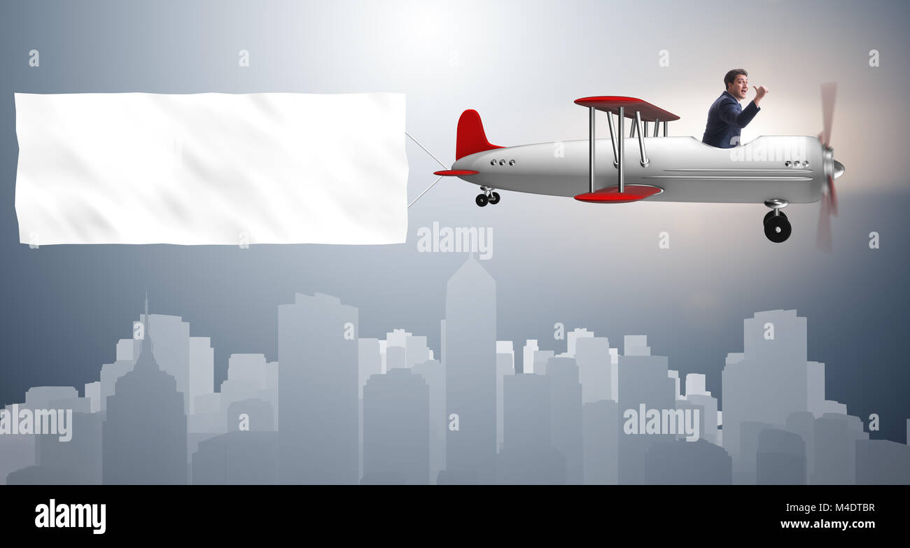 Biplane with businessman and blank banner Stock Photo