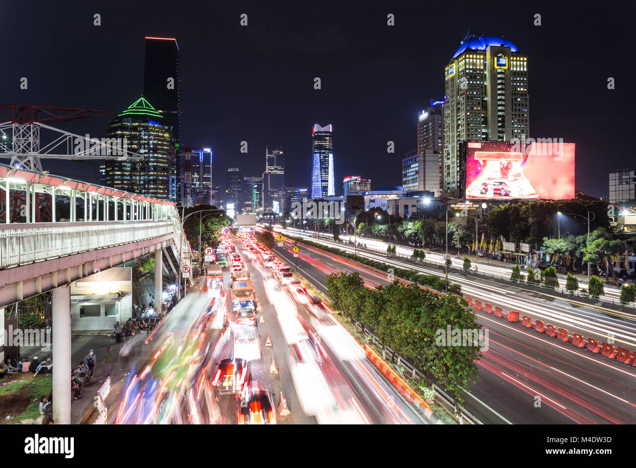 Heavy traffic captured with blurred motion on Gatot Subroto highway in the heart of Jakarta business district in Indonesia capital city at night in So Stock Photo