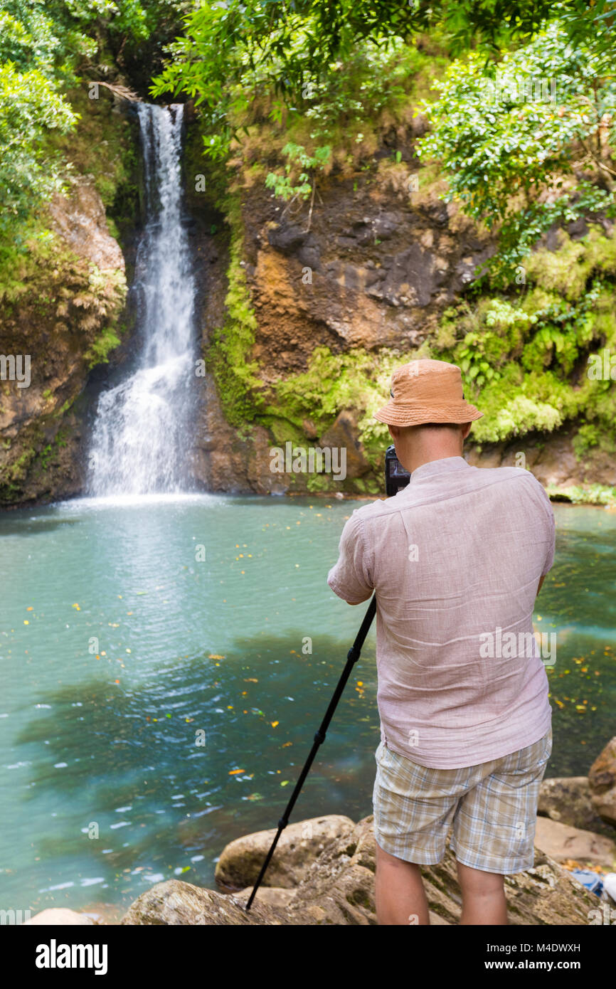 Photographer taking photo of Chamouze waterfall. Mauritius Stock Photo