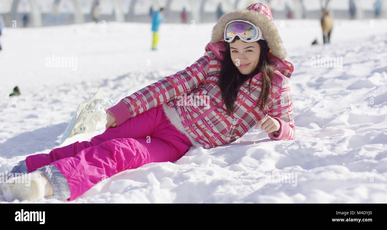 Young woman in pink snowsuit with ski goggles Stock Photo