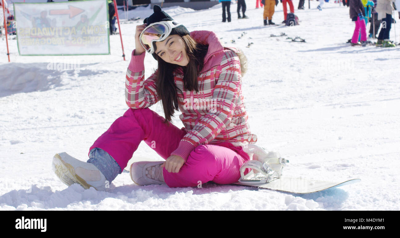 Woman in pink snowsuit with snowboard Stock Photo