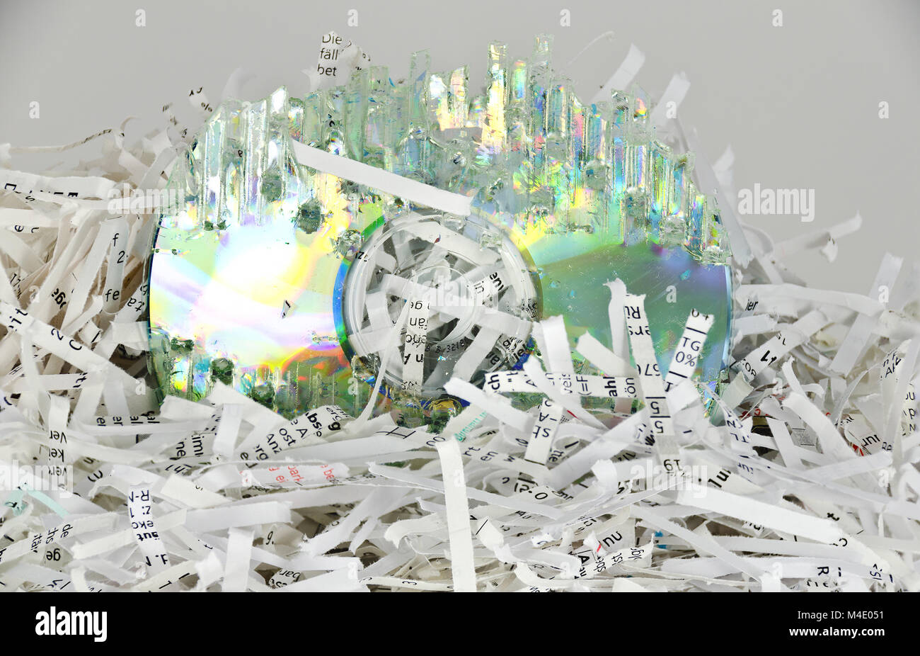 stripes of shredded papers and a destroyed data disc Stock Photo