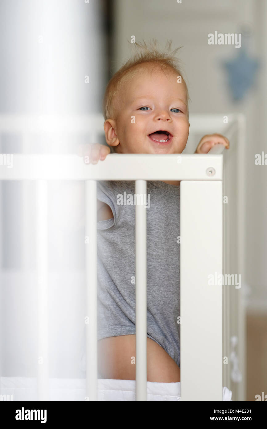 Baby boy standing in crib Stock Photo Alamy