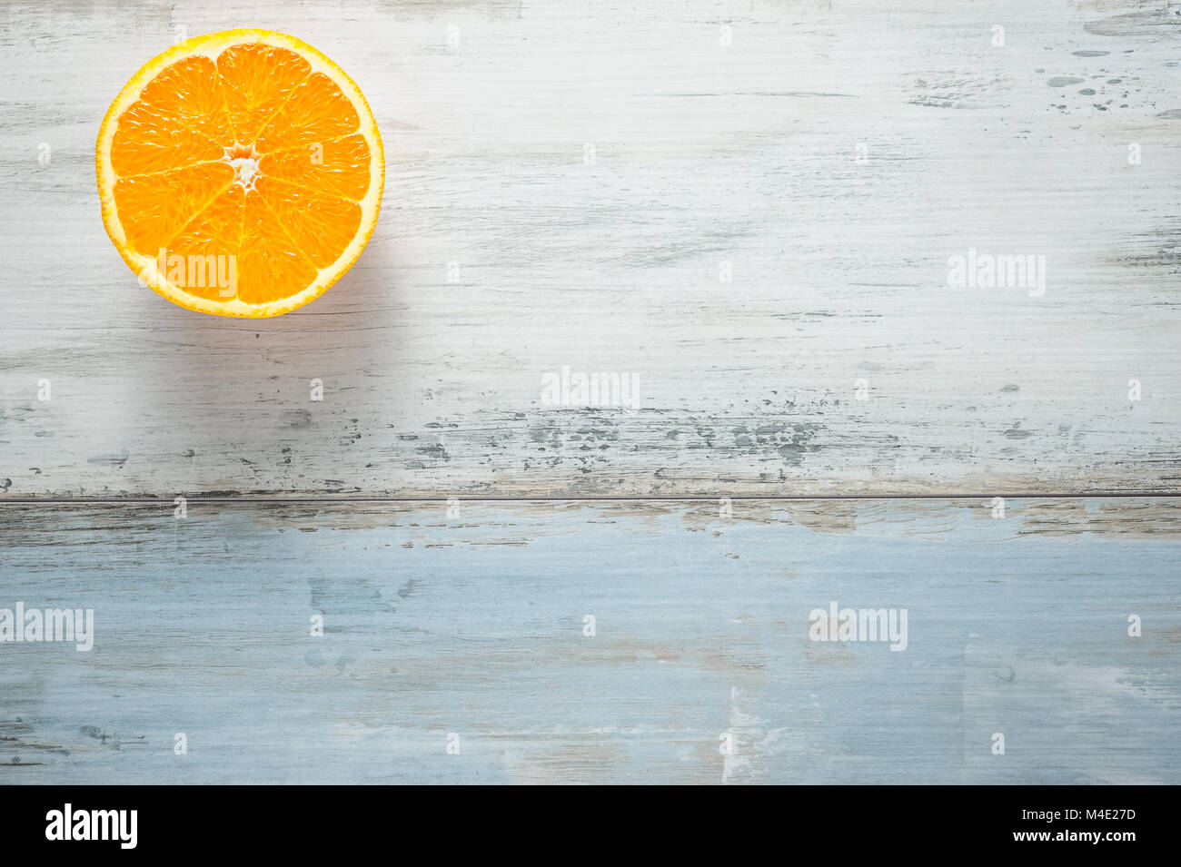 https://c8.alamy.com/comp/M4E27D/one-slice-of-fresh-oranges-on-painted-wooden-board-M4E27D.jpg