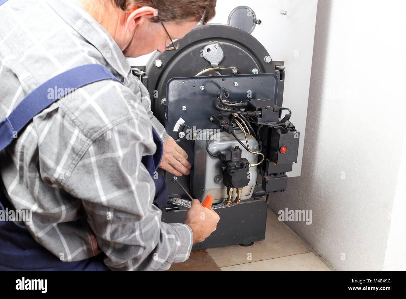 worker is checking an oil burner Stock Photo