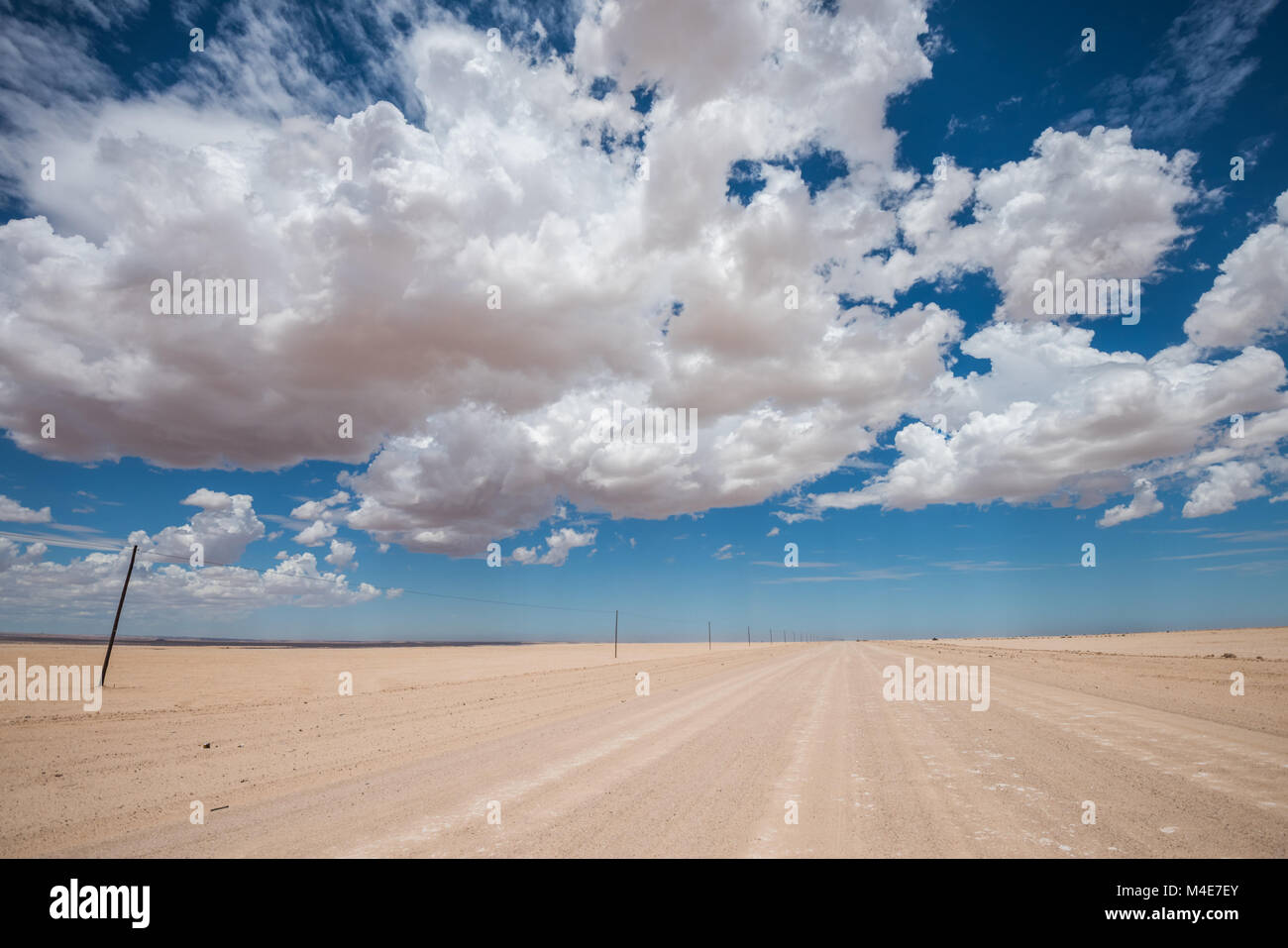 vibrant image of desert road and blue cloudy sky Stock Photo - Alamy