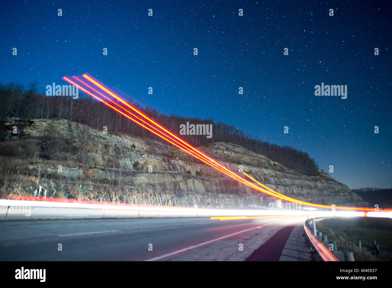 light trails at night in the mountains from outgoing traffic Stock Photo