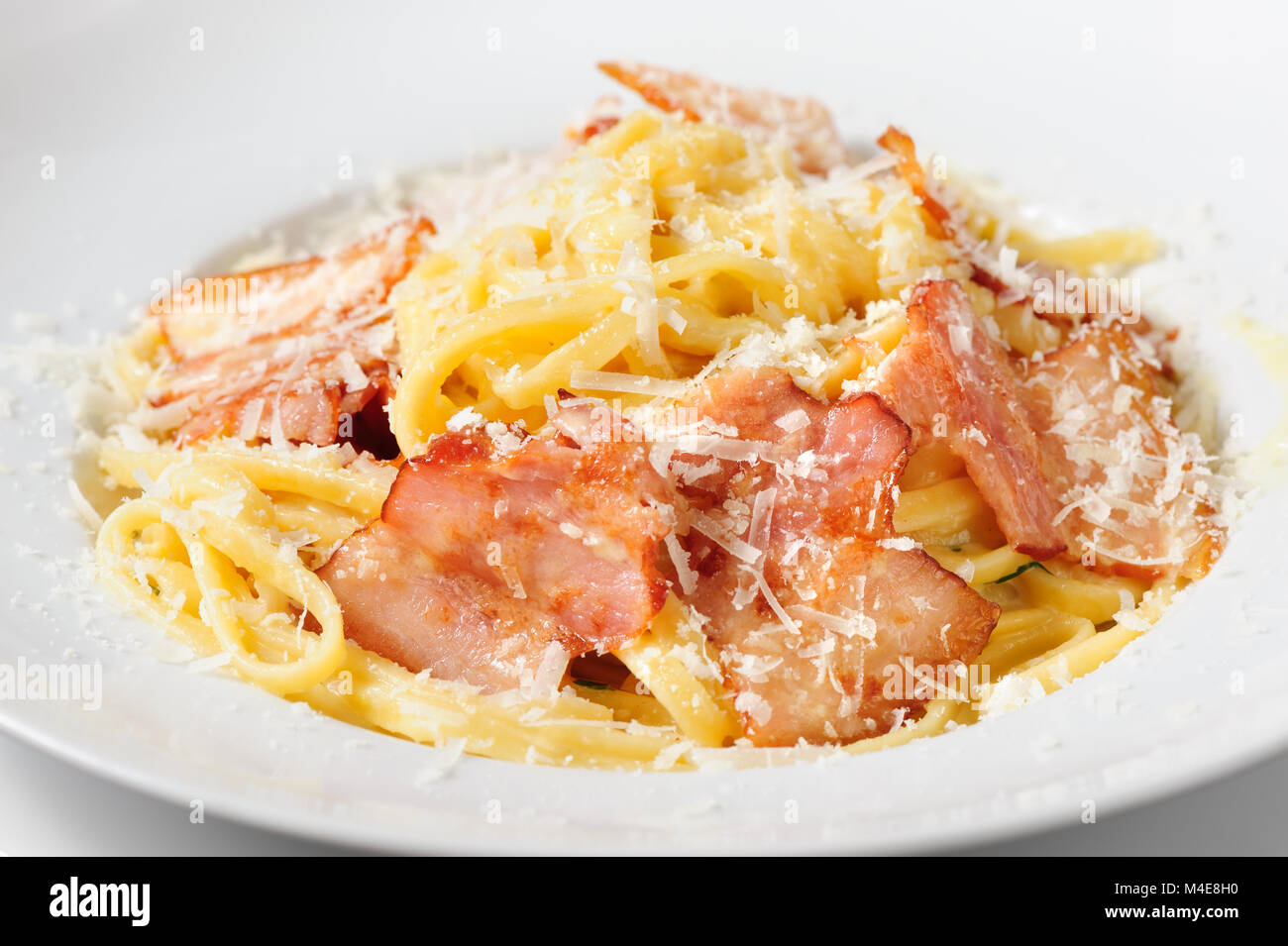 tagliatelli carbanara italian cuisine on plate rustic kitchen table background Stock Photo