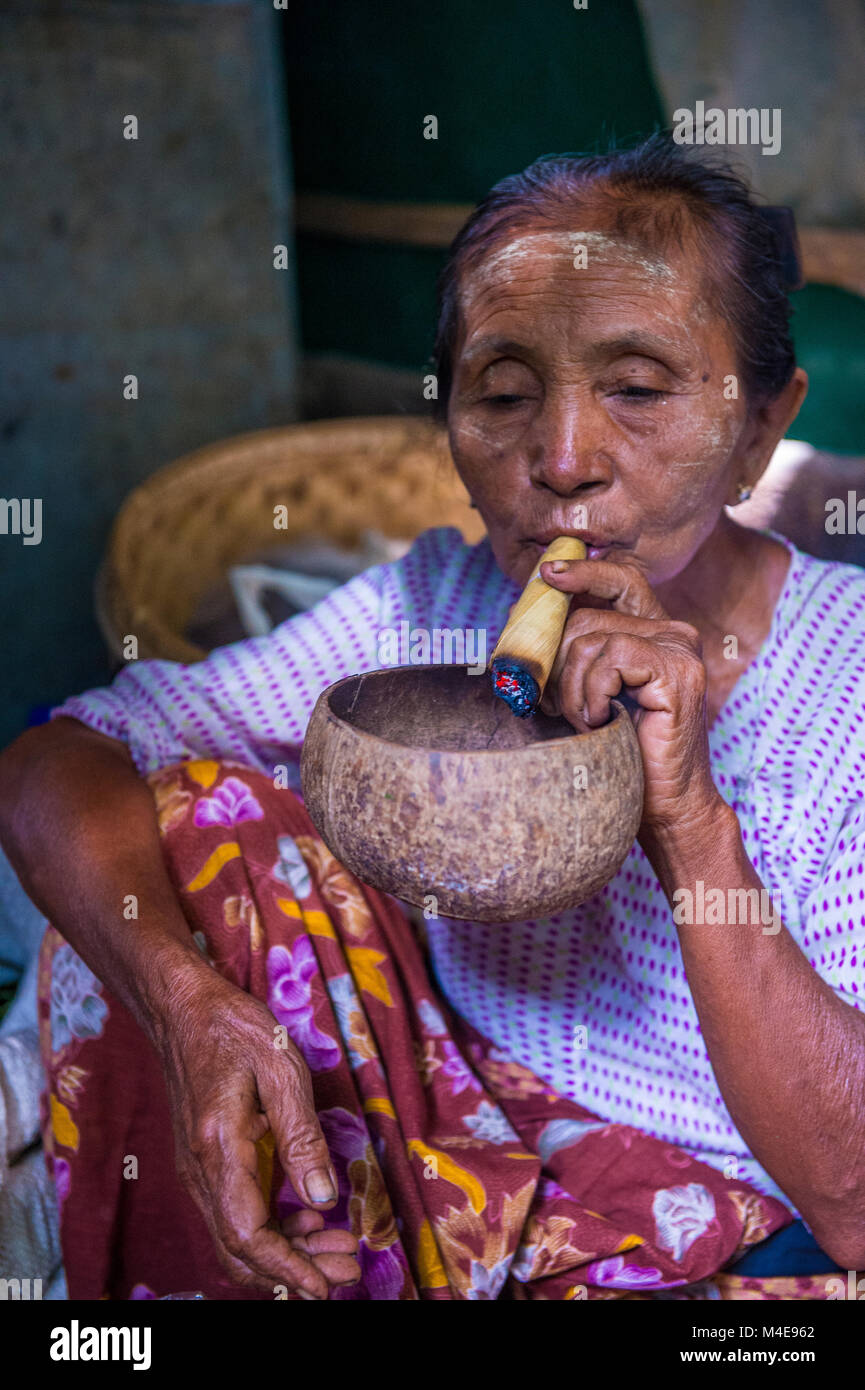Woman smoking a cheroot cigar in market in Bagan, Myanmar Stock Photo ...