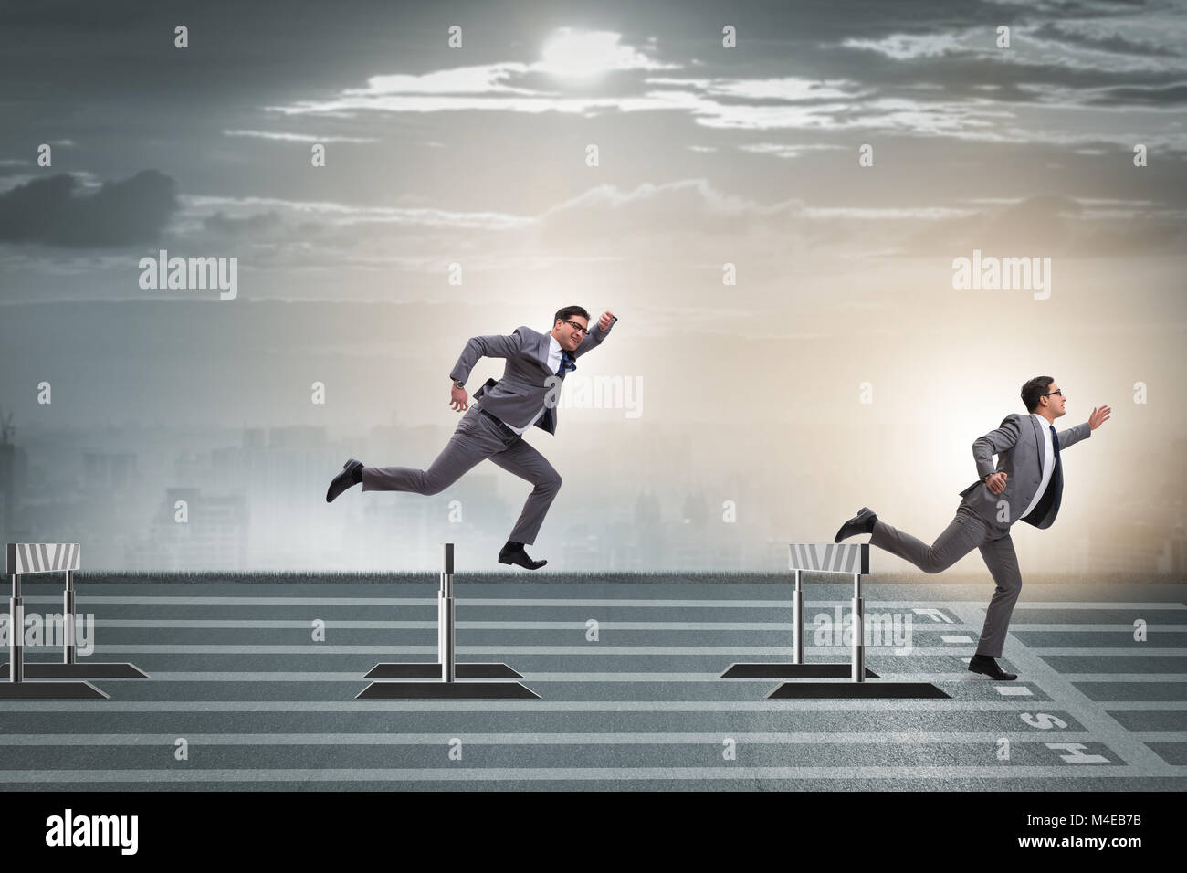 Businessman jumping over barriers in business concept Stock Photo Alamy